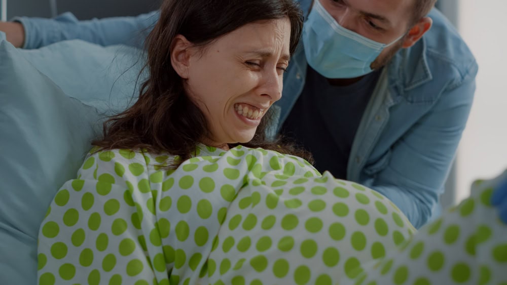 close up pregnant woman pain delivering child hospital ward bed caucasian man helping wife with labor contractions giving assistance couple childbirth preparing parenthood close up pregnant woman pain delivering child hospital ward bed caucasian man helping wife with labor contractions giving assistance couple childbirth preparing parenthood