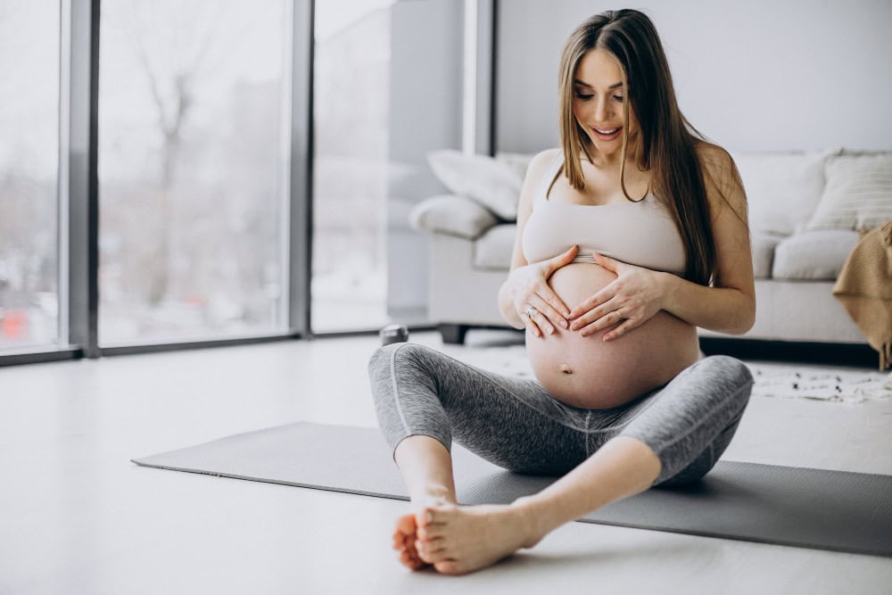 pregnant woman practicing yoga mat home Kadın Doğumu