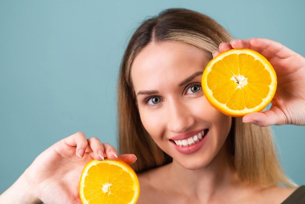 close up portrait topless woman with perfect skin natural make up full nude lips holding fresh citrus vitamin c orange