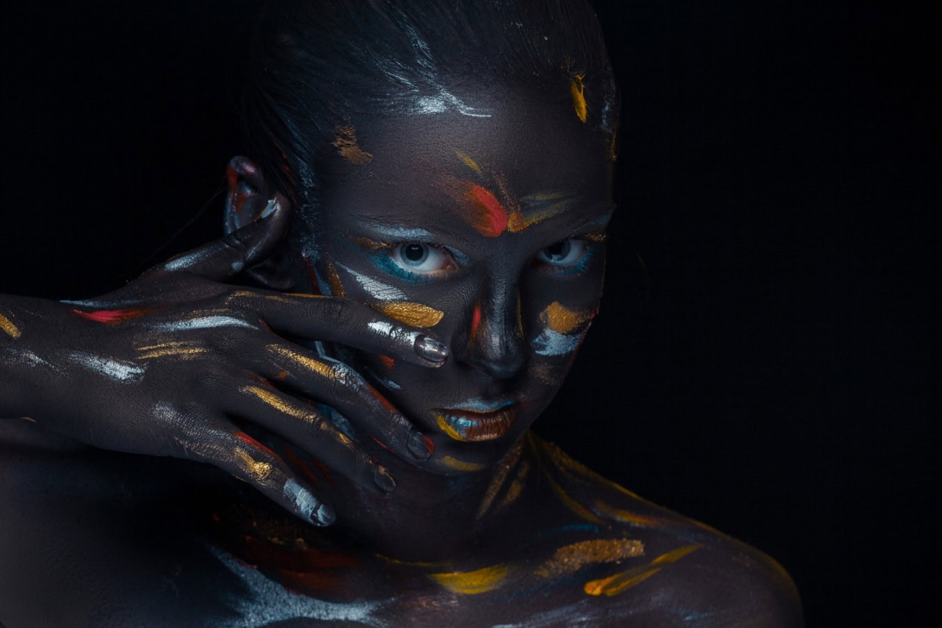 portrait young woman who is posing covered with black paint