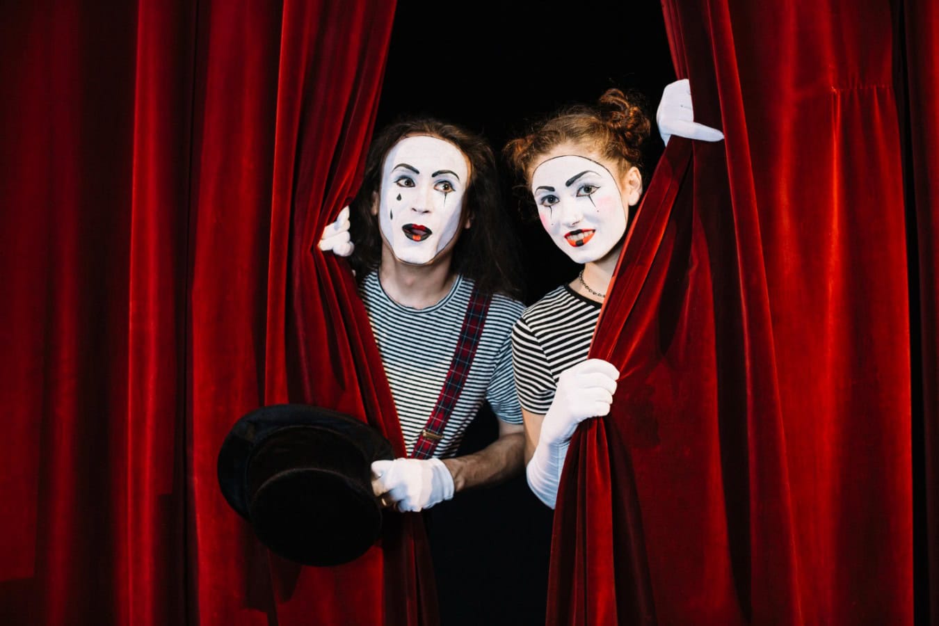 two mime artist peeking through red curtain scaled Tiyatro